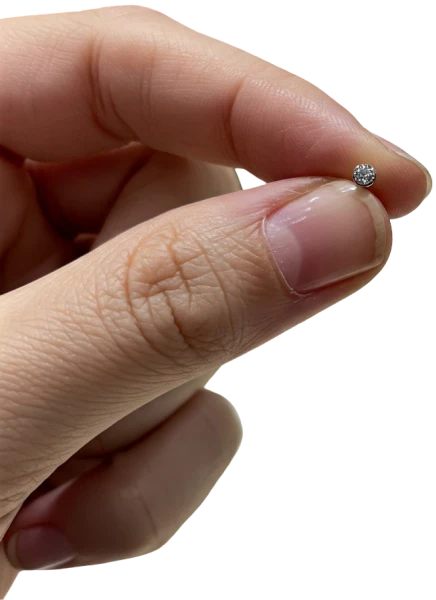 imagem de uma mão segurando uma joia de piercing