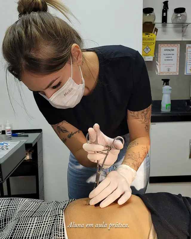 Imagem de aluna executando a aula prática dew piercing